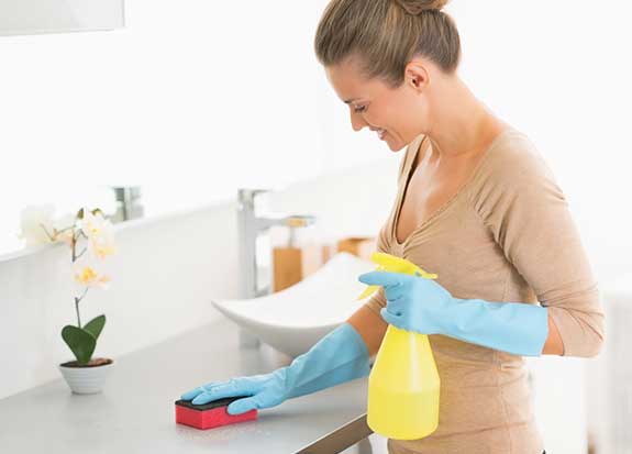 Een vrouw reinigt met bleekmiddel.